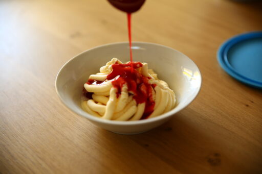 Zum Abschluss für das Spaghetti-Eis die Erdbeer-Sauce darüber geben.