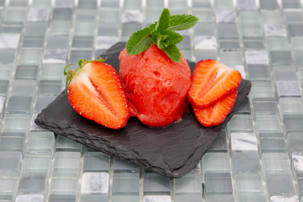 Erdbeersorbet angerichtet mit frischen Erdbeeren und Minze