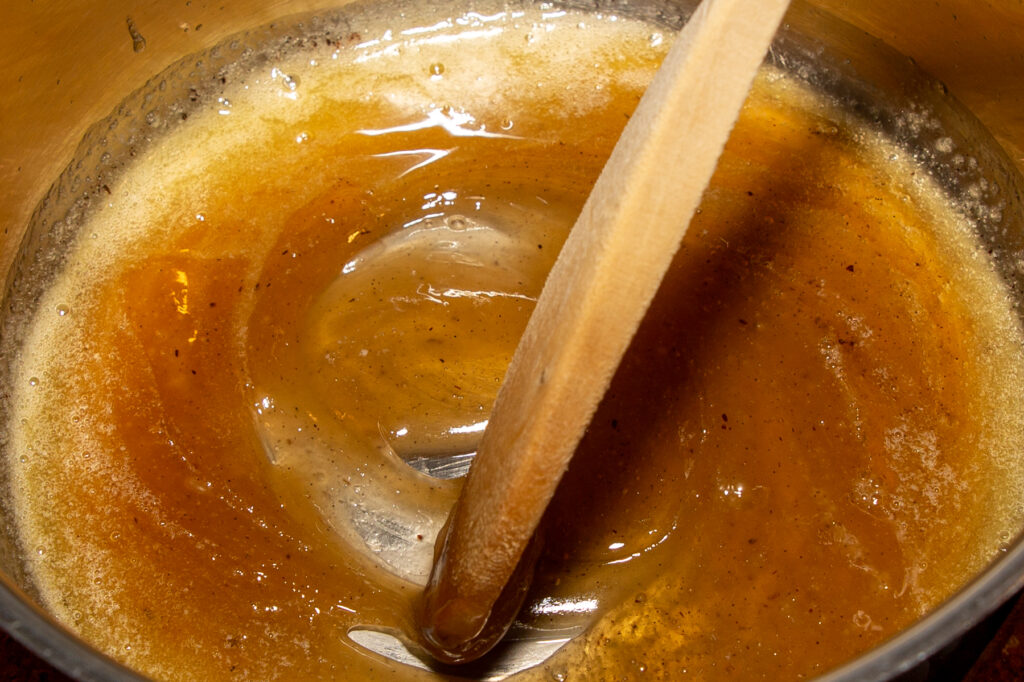 Mit einem Holzlöffel wird die Butter und die Zuckermasse verrührt