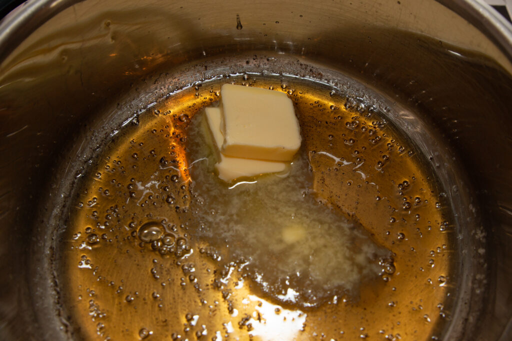 Die Butter wird in die goldfarbene Zuckermasse gegeben.
