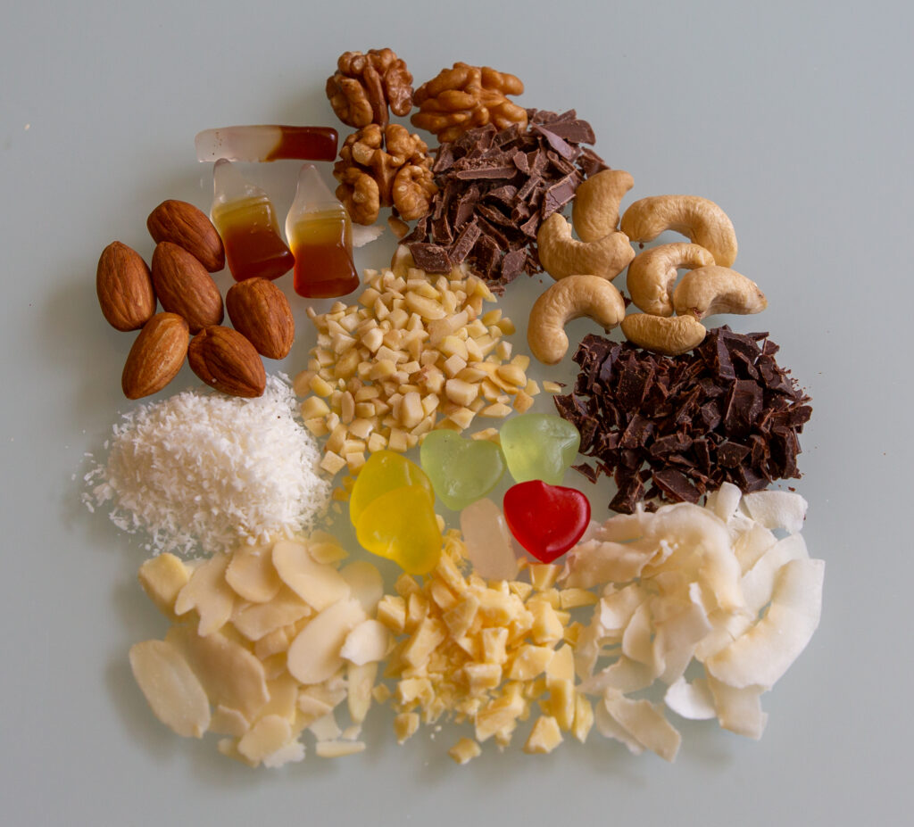 Various toppings for frozen yoghurt. Almonds, walnuts, chocolate, coconut, gummy bears.