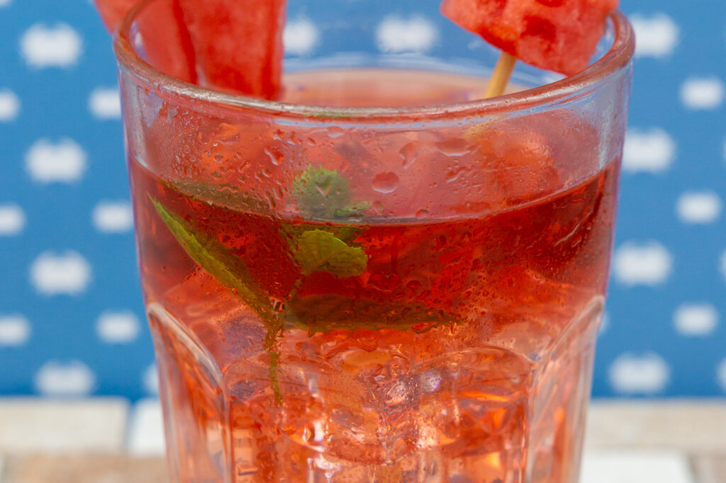 Früchte-Eistee mit Wassermelone und Minze dekoriert