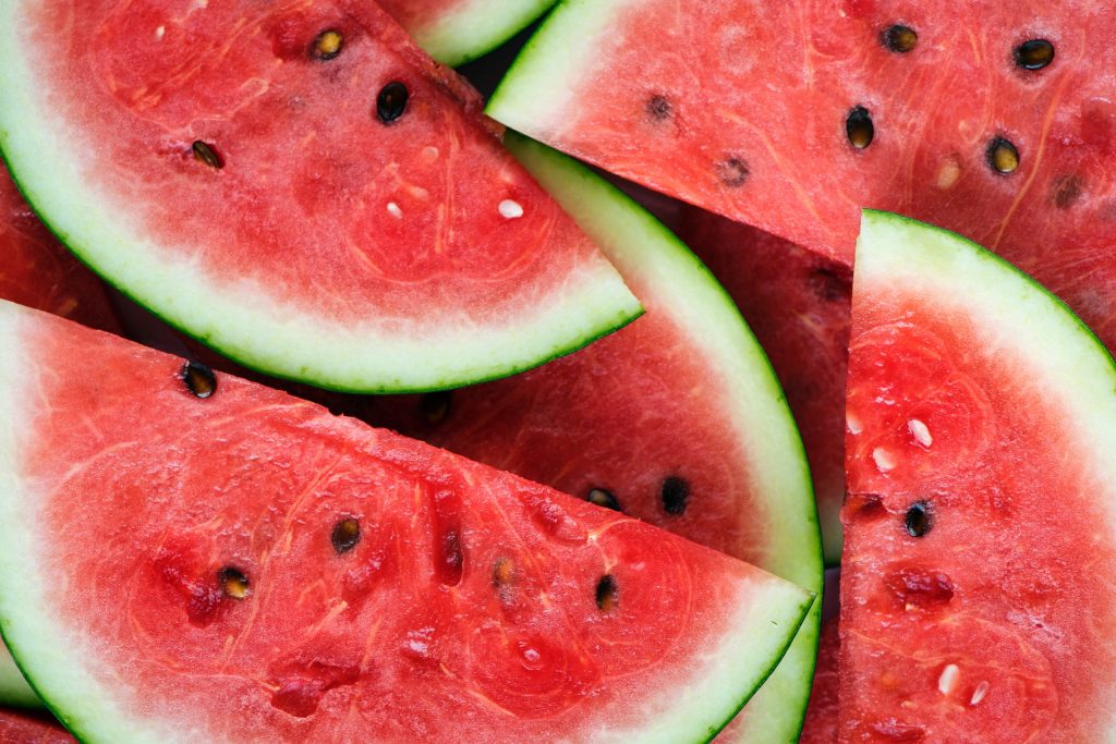 Dark red watermelon slices with green skin and brown seeds