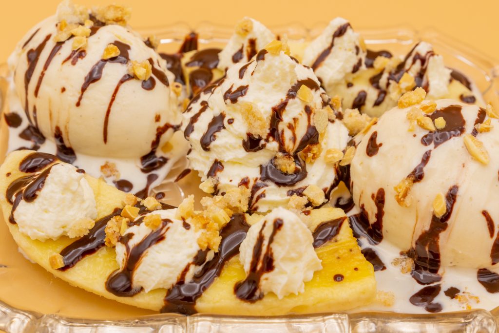 Banana split in the typical German variant: vanilla ice cream, bananas, cream and chocolate sauce. Here still decorated with caramelized nuts.