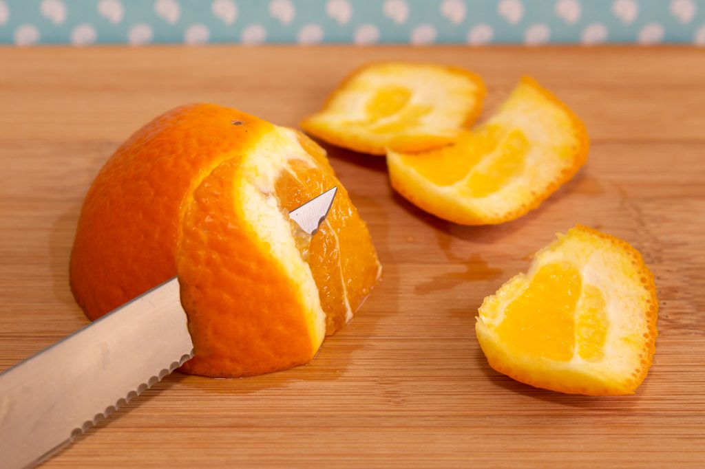 Cut the orange in half and cut the peel into strips along with the white skin.