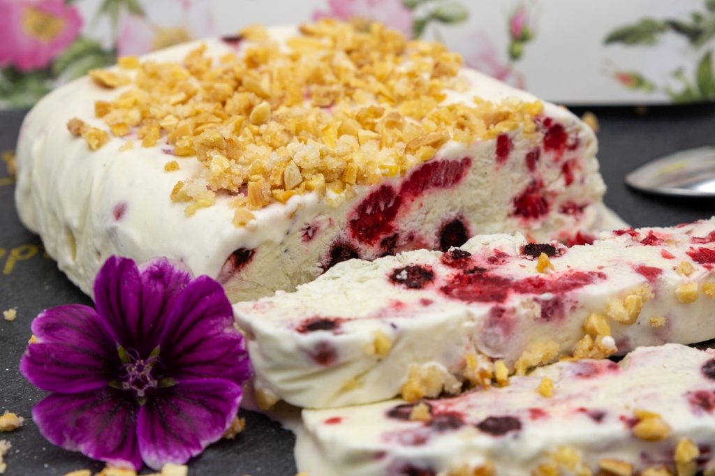 Tonkabohnen-Eis mit Heidelbeeren und Himbeeren dekoriert mit karamellisierten Nüssen.