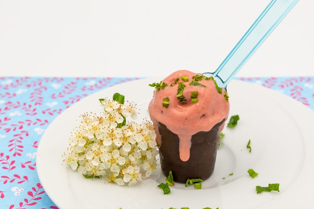 Strawberry ice cream garnished with mint.