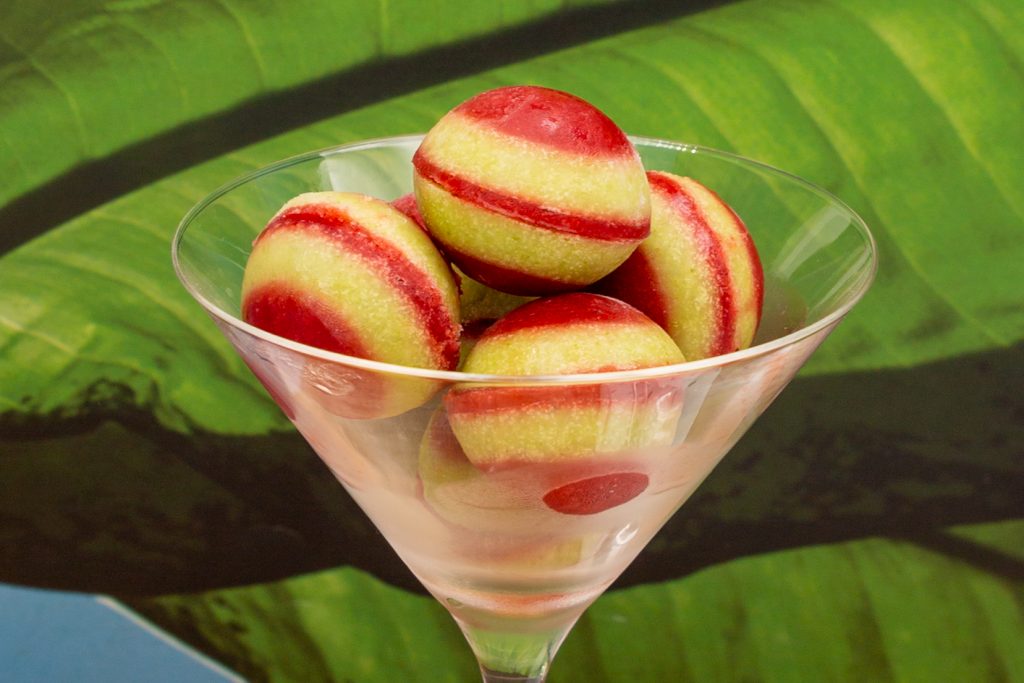 Pineapple ice cream layered with strawberry sorbet as balls.