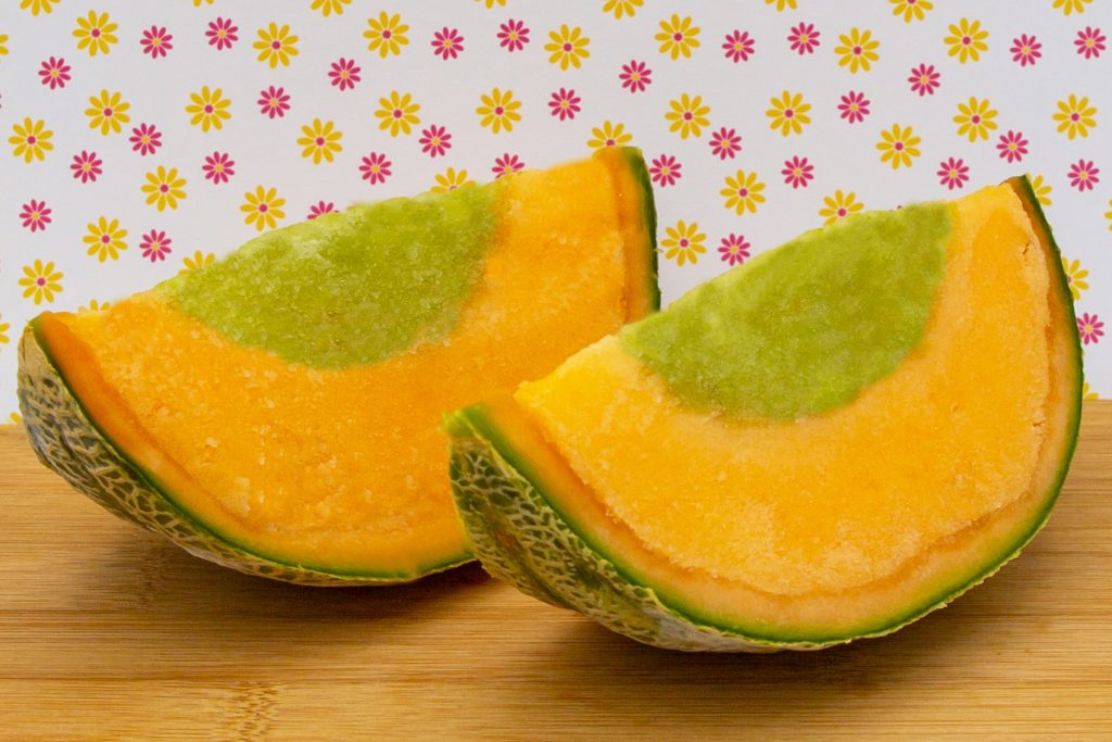 Melonen-Sorbet angerichtet in der Melonenschale und gefüllt mit Ananas-Eis.