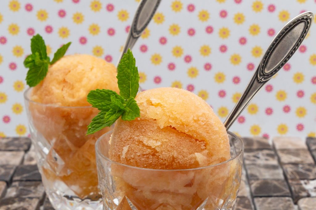 Grapefruit-Sorbet Erfrischendes Grapefruit-Sorbet dekoriert mit Minzblättern.