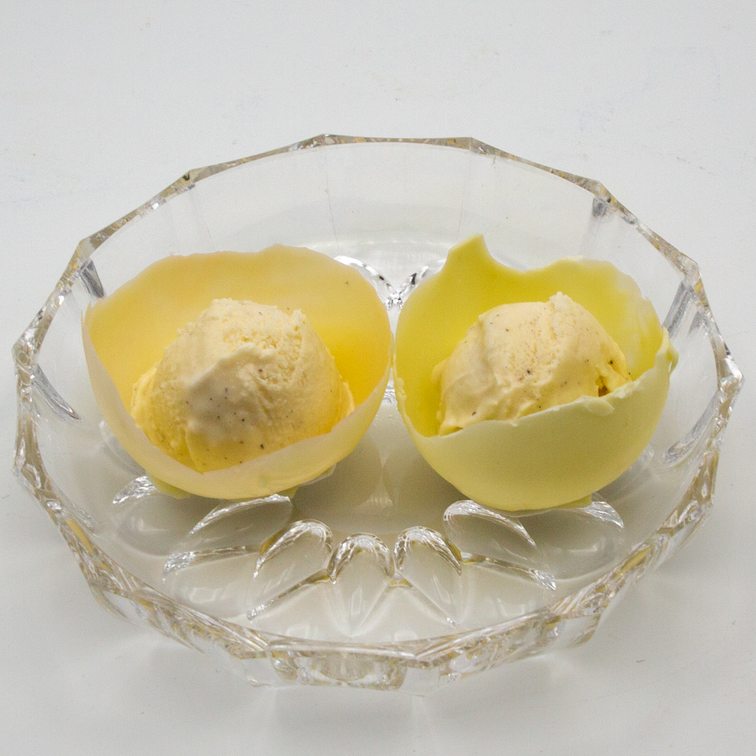 Put vanilla ice cream balls into the white chocolate bowls.