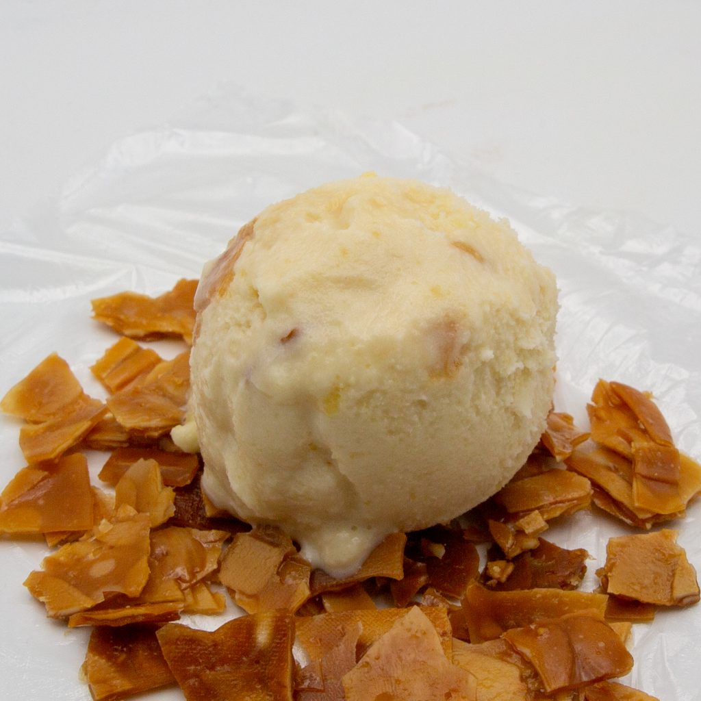 A scoop of bee sting ice cream on almond brittle.
