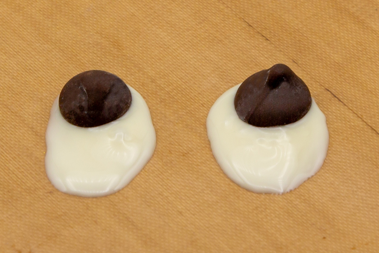 For the eyes, an oval with white chocolate is applied to baking paper and a dark chocolate drop is placed inside.