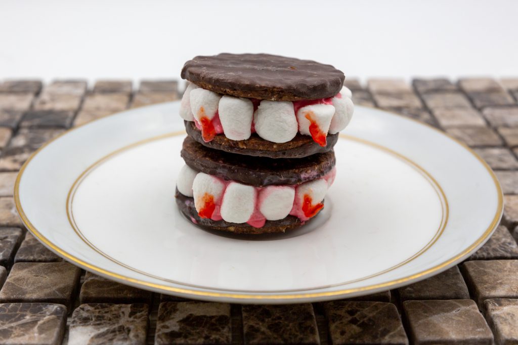 Die Vampirzähne können noch zusätzlich mit roter Zuckerschrift verziert werden, um Blutstropfen zu imitieren.