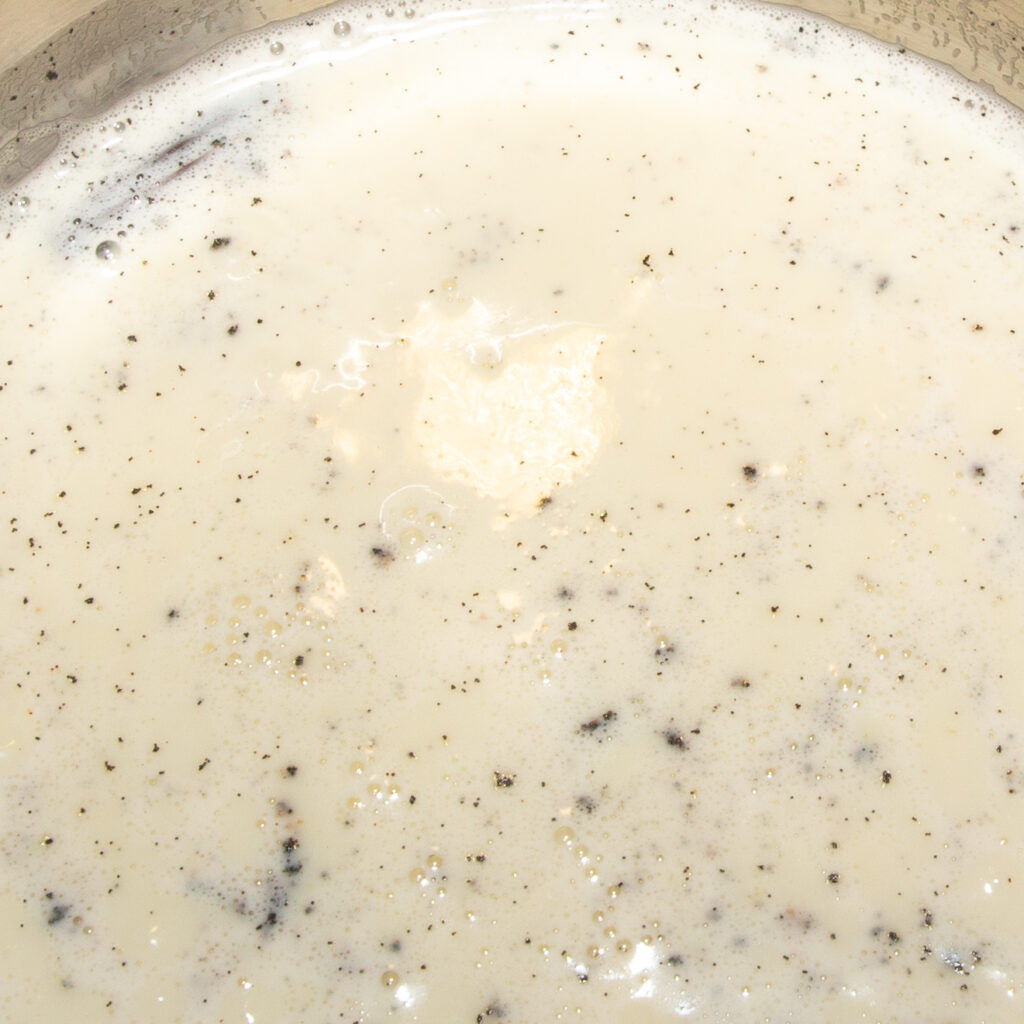 Stir the dissolved starch into the warm milk.