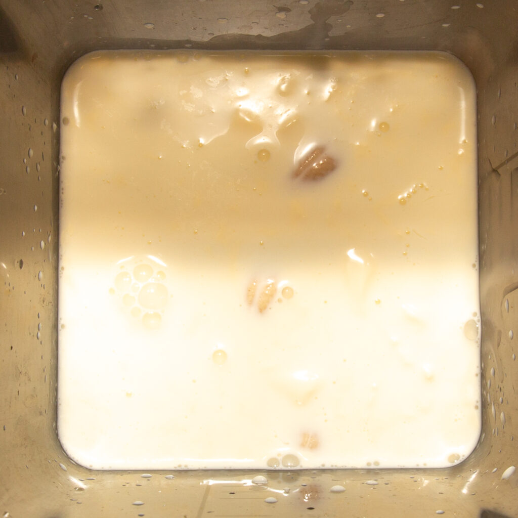 Cashewkerne mit Milch und Sahne im Mixer.
