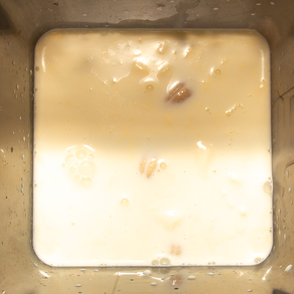 Cashews with milk and cream in a blender.