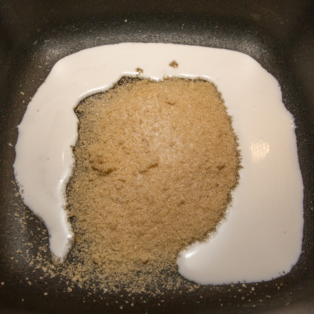 Zucker und Kokosnussmilch in einer Pfanne erhitzen.