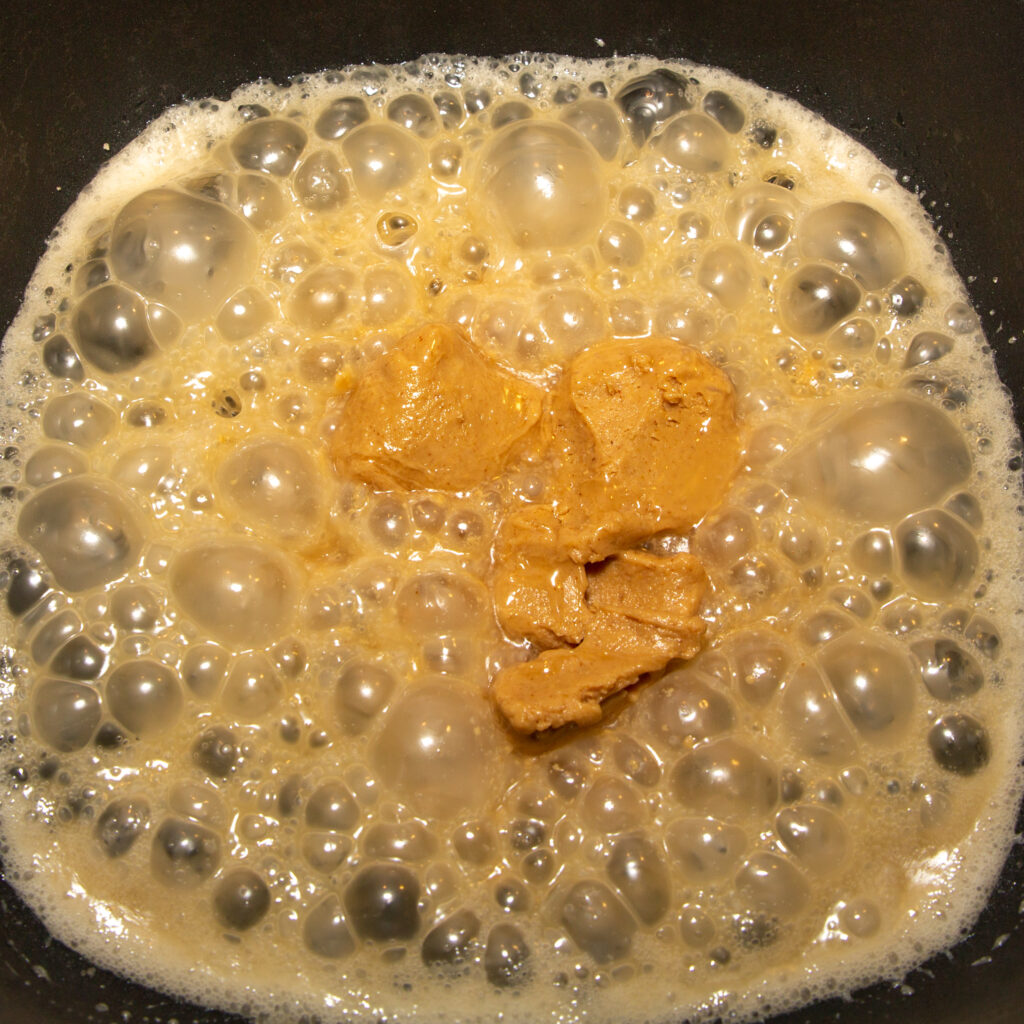 To the boiled coconut milk sugar, add the peanut butter and mix well.