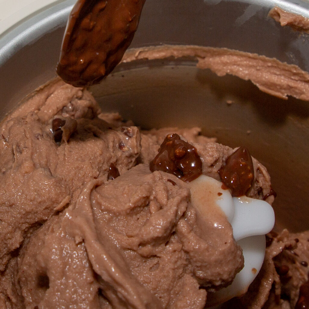 At the end of the freezing process, drizzle in the melted chocolate nut pralines.
