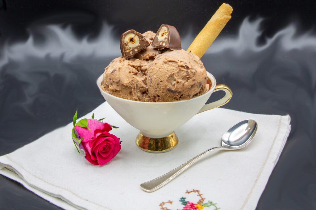 Bacio-Eis Bacio-Eis angerichtet mit einer halbierten Schokonuss-Praline und Waffelröllchen.