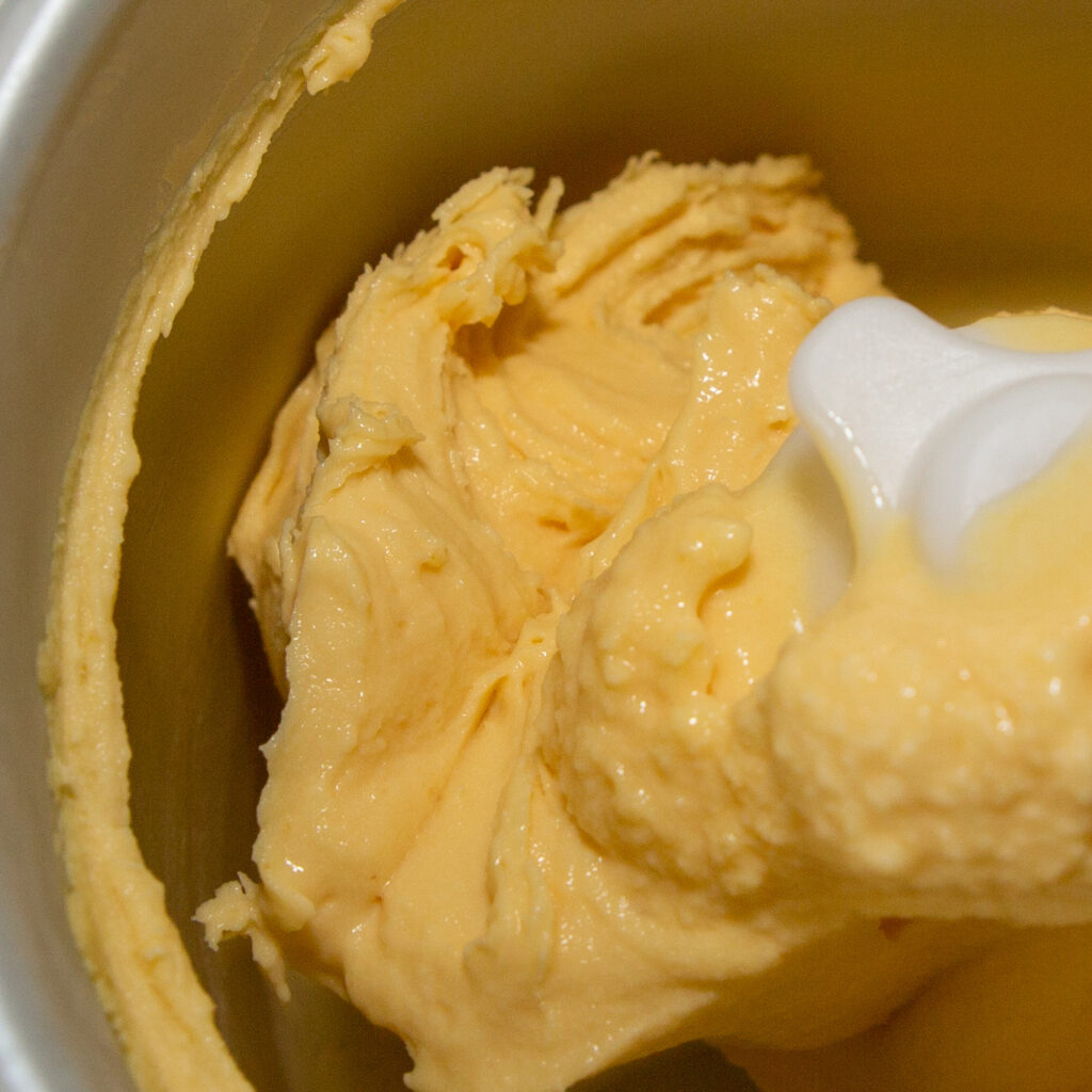 Frozen mango ice cream in the ice cream maker.