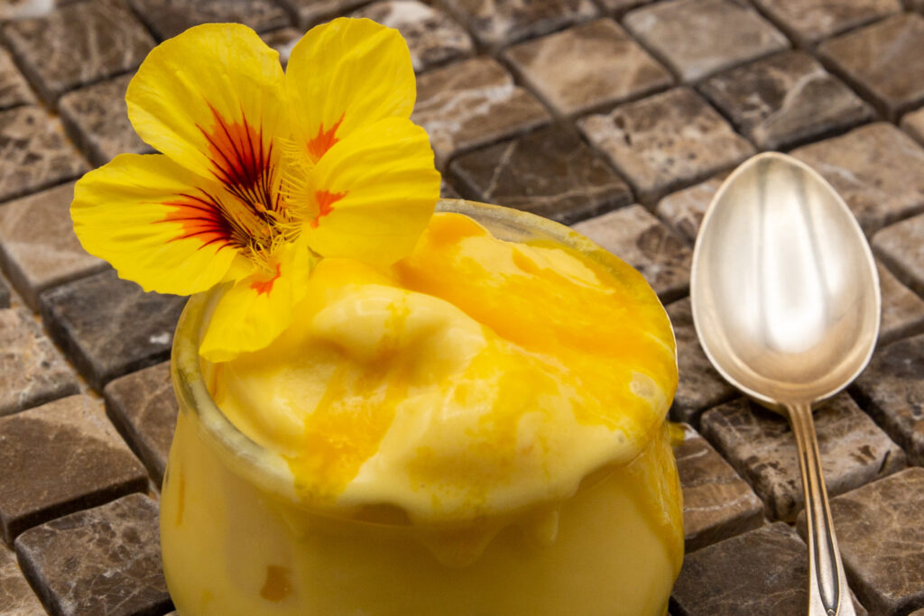 Creamy mango ice cream - here decorated with a beautiful capuchin flower. These flowers are edible.