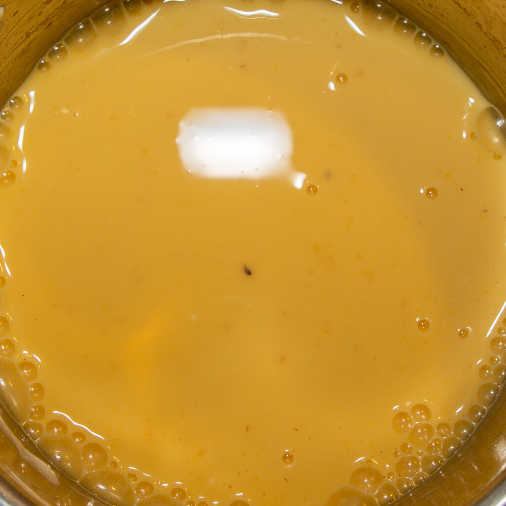 Maracuja-Eis Nach dem Abkühlen des Maracujasirups wird der Joghurt eingerührt. Die kleinen braune Stückchen kommen von der Tonkabohne.