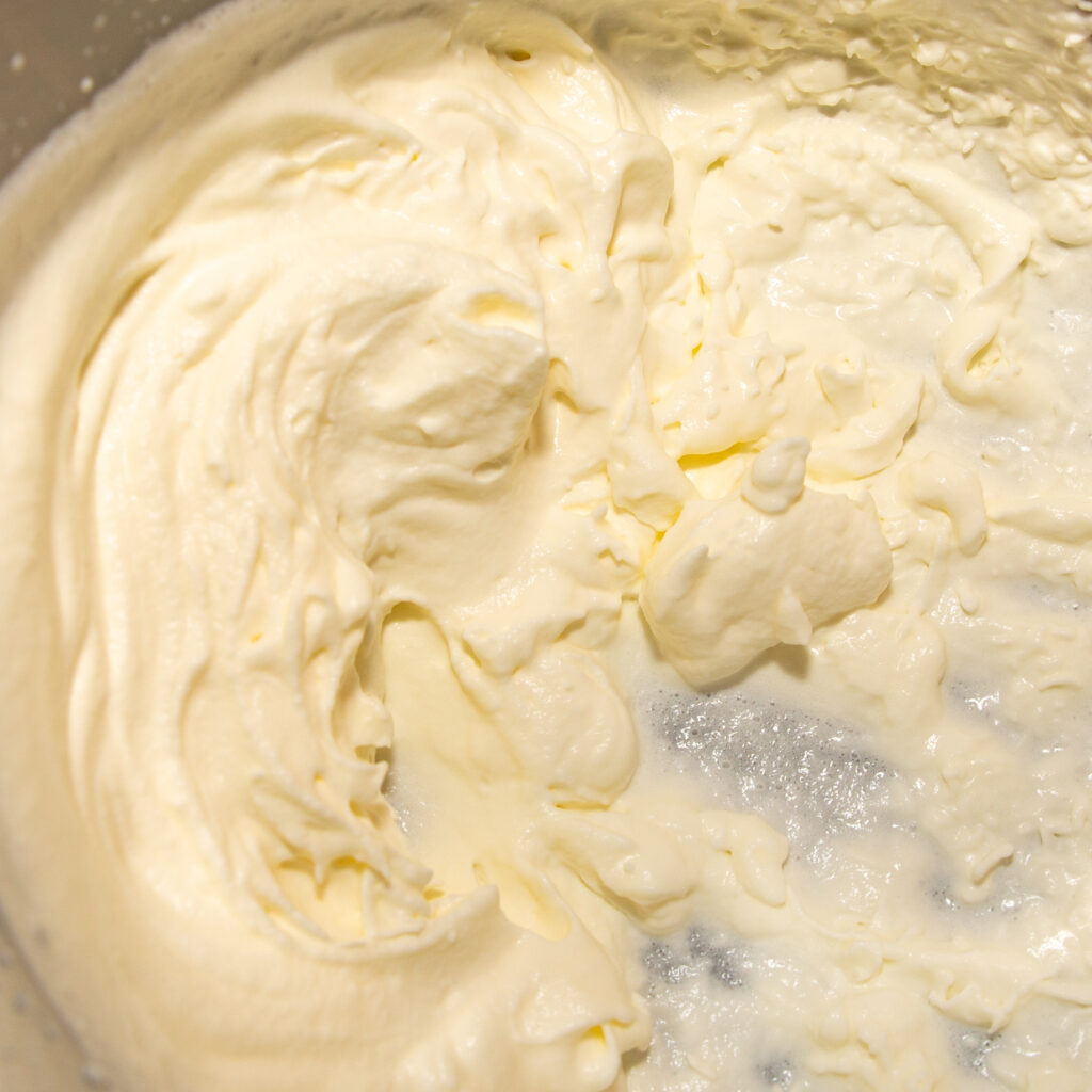 The cream is whipped until stiff and folded in before preparing the ice cream.