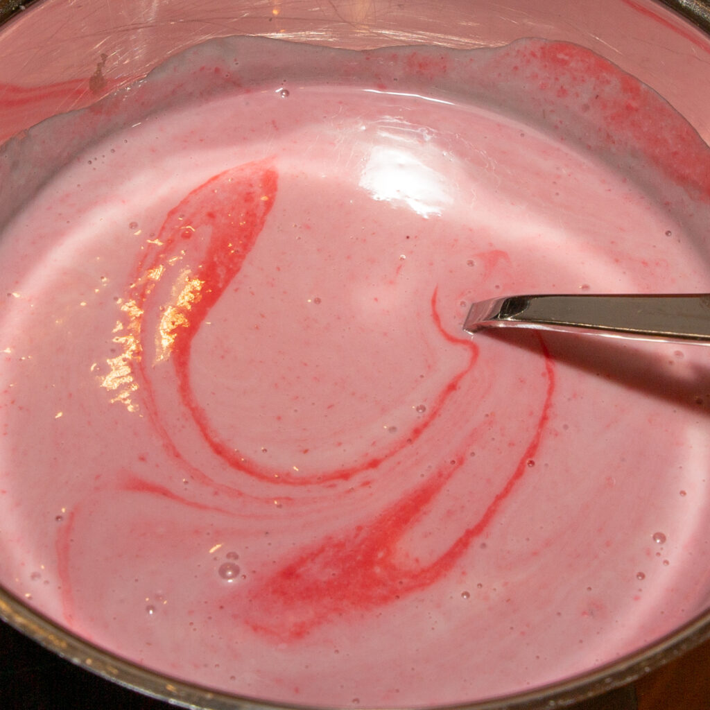 Stir the raspberry puree into the milk ice cream mixture.