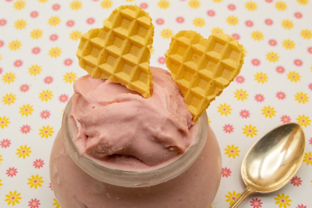 Creamy raspberry ice cream decorated with cut out wafer hearts.