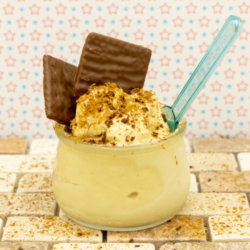Helado de plátano decorado con virutas de chocolate y adornado con barritas de canela y chocolate