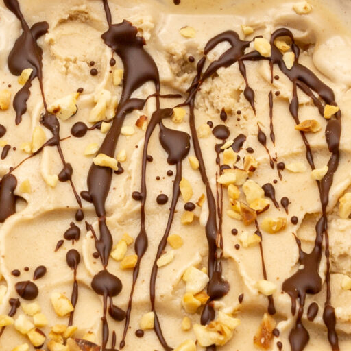 Wenn das Haselnuss-Eis fertig ist, kann es im Behälter wie in der Eisdiele mit Schokolade und Haselnüssen verziert werden.