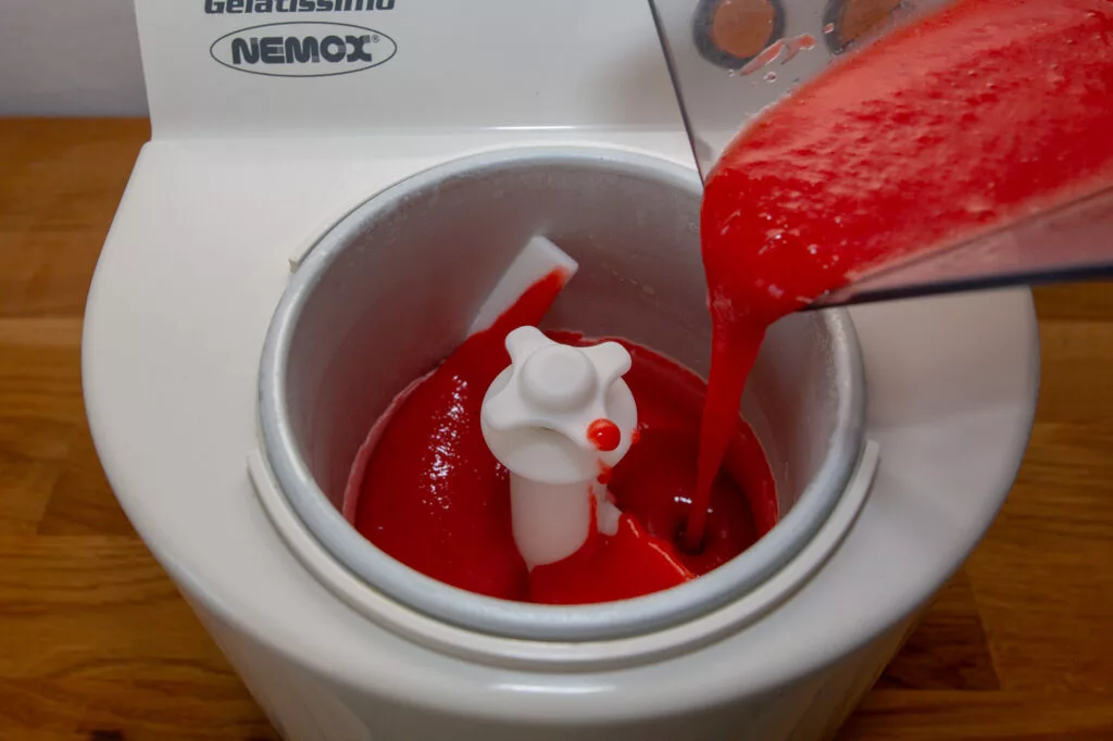 Introducir la mezcla de frambuesas y frutas en la heladora para que cuaje.