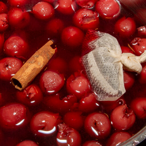 Die heißen Kirschen werden mit Zimtstange und Pfefferkörnern gekocht.