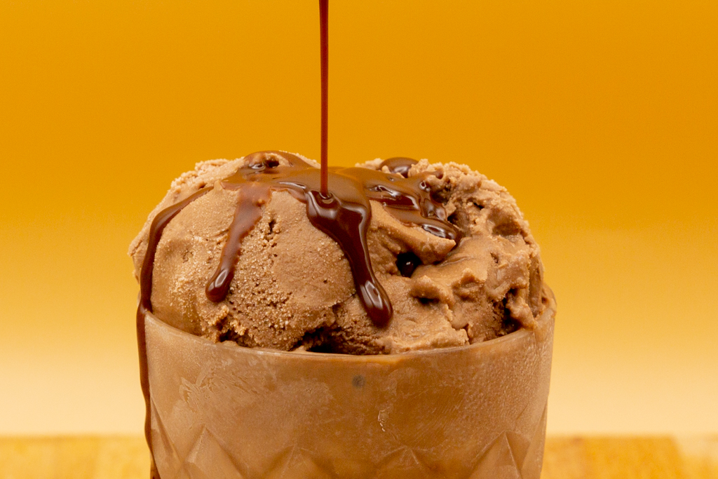 The low carb chocolate sauce is initially liquid and becomes hard and crunchy on contact with the cold ice cream.