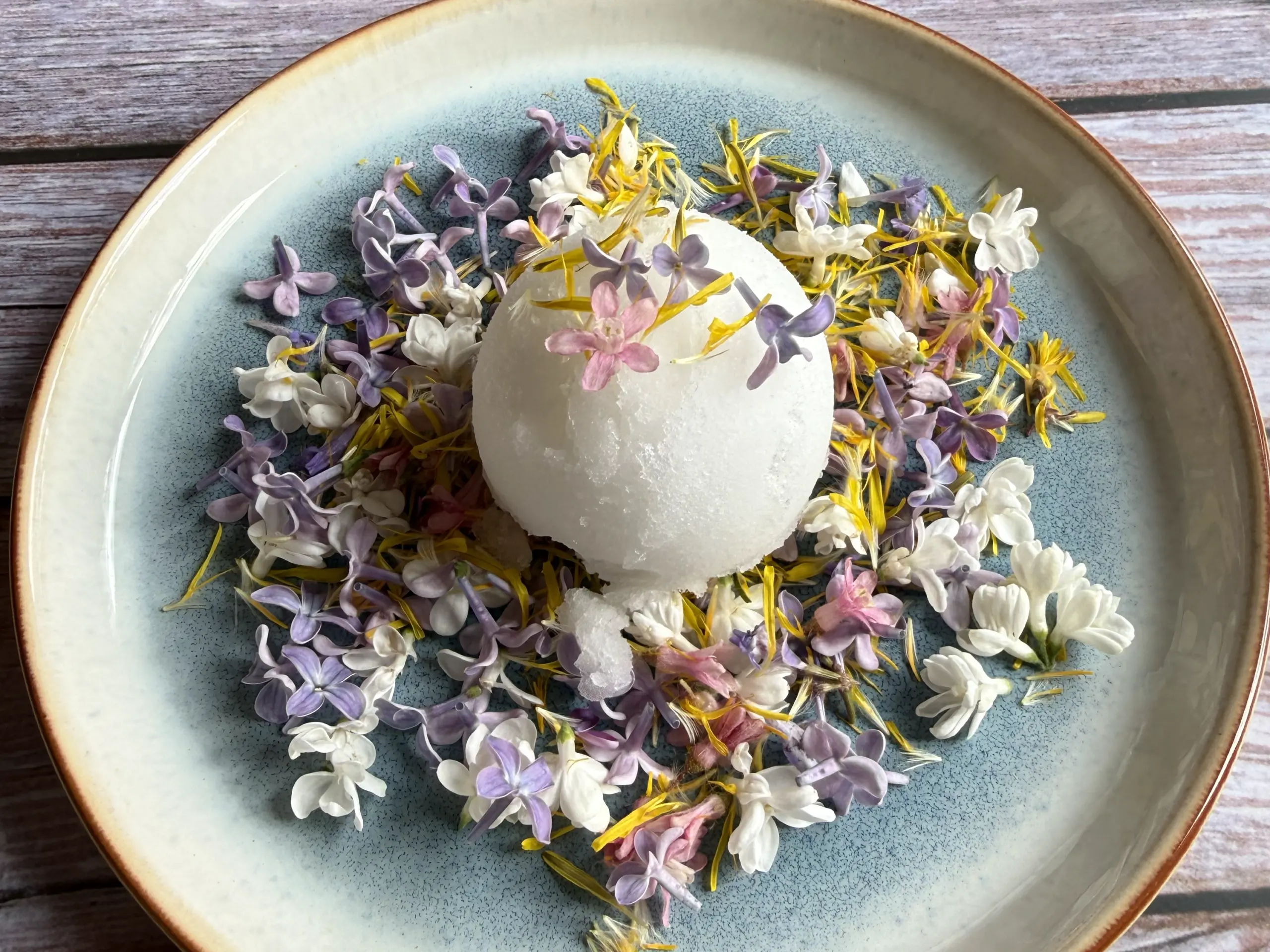 
Essbare Blüten wie Flieder, Löwenzahn, Johannisbeere und Gänseblümchen eignen sich gut als Dekoration von Eis und Desserts.